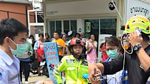 An injured child is carried on a stretcher after a school shooting in Thailand.