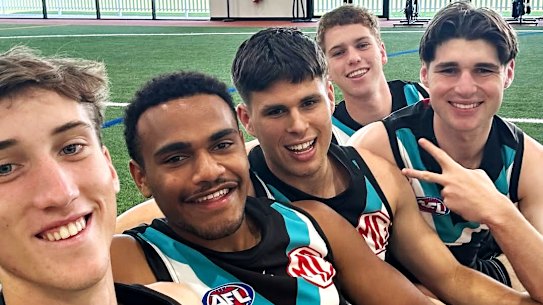 Port Adelaide footballer Tom Cochrane (centre) is congratulated by teammates (L-R) Jack Whitlock, Benny Barrett, Joe Berry and Christian Moraes after the club named him to make his debut.