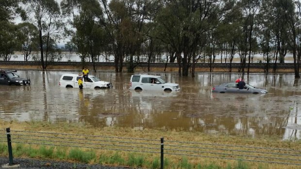 Passengers were seen sitting on the roofs of cars stranded on the Hume Freeway between Springhurst and Wangaratta as the state was hit by heavy rain.