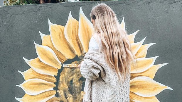 Artist Holly Ogden paints sunflowers all over Perth.