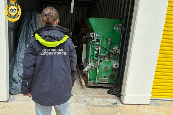 A border official inspects the storage unit after it was raided.