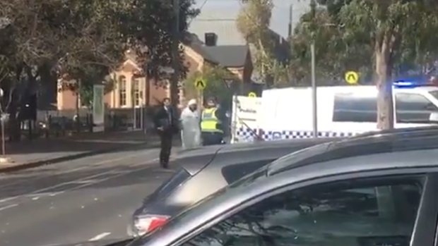 The man is taken into custody outside St Mary's Anglican Church in North Melbourne.