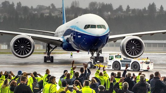 Boeing employees and family members cheer the 777X after it landed at Boeing Field in Seattle, completing its first flight on Saturday, Jan. 25, 2020. (Mike Siegel/The Seattle Times via AP)