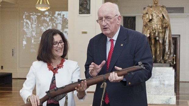 Former deputy prime minister Tim Fischer hands over his Enfield 303 rifle to Museum of Australian Democracy director Daryl Karp at Old Parliament House.
