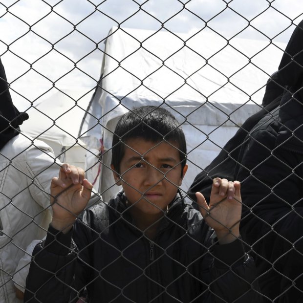 Foreign IS wives and children at the fence line of the Foreign section of al- Hawl camp in Syria, in April.