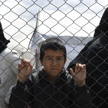 Foreign ISIS wives and children at the fence line of the Foreign section of Al Hawl camp in Al Hawl, Syria, in April.