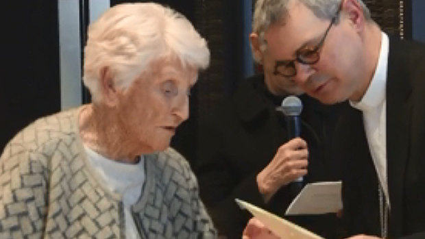 Eileen Piper, 93, shows Catholic archbishop Peter Comensoli a picture of her daughter at his Melbourne Press Club appearance.