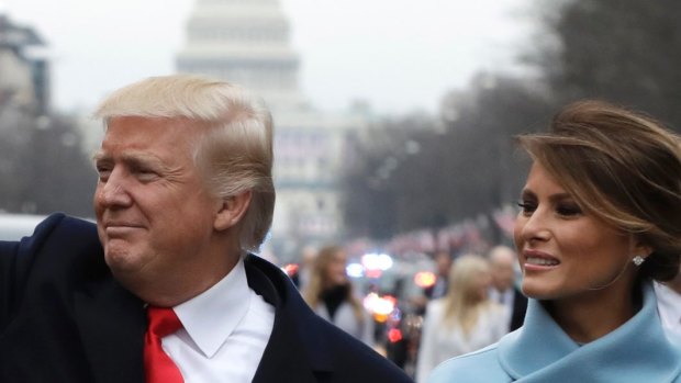 President Donald Trump waves as he walks with first lady Melania Trump during the inauguration parade on Pennsylvania Avenue in Washington.