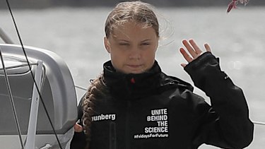 Climate change activist Greta Thunberg waves from the Malizia II boat in Plymouth, England.