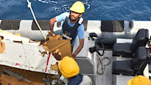 Debris from the missing cargo plane is recovered by searchers off the Pakistan coast.