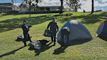 Council officers are seen dismantling and removing tents.