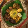 Lamprais: Rice (cooked in rich stock), plus one or two meat or vegetable curries, a spiced meatball (sometimes replaced with a fish cutlet), a boiled egg, some eggplant sambal and coconut belacan, all wrapped in a banana leaf.