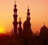 Domes and minarets dot the skyline at sunset in Cairo.