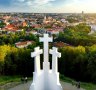 Aerial view of the Three Crosses monument overlooking Vilnius Old Town on sunset. 