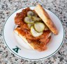 Fried chicken sandwich with deep-fried meat, hot honey butter and crinkle-cut pickles.