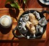 Potato damper on eucalyptus skewers, cooking on hot coals at your table.