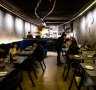 The 12-metre loop of halo lighting, blue velvet banquettes and distressed, charcoal-daubed walls at Soul Dining.
