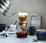 Preparing a filter coffee using the pourover method with a Chemex flask and gooseneck kettle.