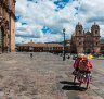 Two women wearing traditional clothes walking in the Plaza de Armas, in Cusco.