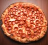Pepperoni pizza is assembled with precision.
