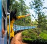 A woman enjoys the train ride through Sri Lanka tea plantations.