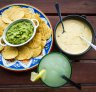 Con queso and guacamole dips with corn chips.