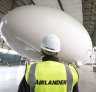 A worker stands in front of the Airlander 10 hybrid airship.