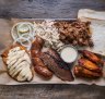 "Pitmaster selection" platter (clockwise from top right) pulled pork, buffalo hot chicken wings, brisket, house-made sausage, smoked chicken breast with Alabama-style white sauce, pickles and coleslaw.