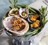 A mini seafood tower holding oysters with finger lime, barbecued abalone skewers and mussel escabeche.