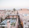 Pink-hued buildings stand among narrow alleyways in Marrakech.