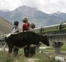 A Train from Lhasa Railway Station travels on the Tibetan grasslands near Lhasa, Tibet.