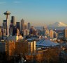 The Seattle city skyline at sunset with the Space Needle, downtown and Mount Rainier from Queen Anne Hill.