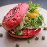 House-made beetroot bagel filled with salmon, watercress and egg.