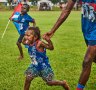 Young fans run on to the ground at the Tiwi Islands Football Grand Final.