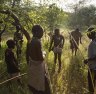 Hadza hunters with bows and arrows tracking game. 