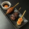 A platter with tsukune (chicken meatball), wagyu and scallop skewers.