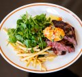 Grilled-and-sliced black angus rib eye topped with tomato butter with a good handful of watercress.