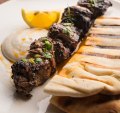 Skewered lamb rump with grilled flatbread and a squeeze of lemon.