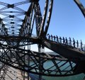 Don't look down: Cars zoom below bridge climbers.