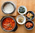 The signature tofu soup, sundubu-jjigae (bottom left), comes with banchan (snacks) and rice.