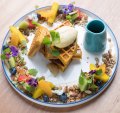 Spiced pumpkin waffle encircled by fruit, nuts and seeds.