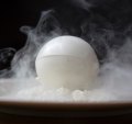 A white chocolate sphere contains coffee-soaked cake and whipped vanilla cream.