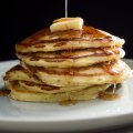 A stack of perfect buttermilk pancakes with butter and maple syrup.