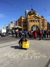 Protesters stop traffic outside Flinders Street during action against Operation Border Force. 