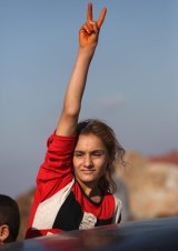 A Yazidi refugee celebrates news of the liberation of her homeland of Sinjar from IS extremists at a refugee camp in Syria.