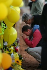Stephanie Scott's mother Merrilyn Scott and her fiance Aaron Leeson-Woolley outside a makeshift memorial at Leeton High School shortly after the murder. 