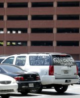 A demonstrators car is seen within the crime scene near the parking garage where Johnson died after writing the mysterious initials in blood.