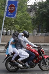 Commuters ride past an anti-rape sign in New Delhi.