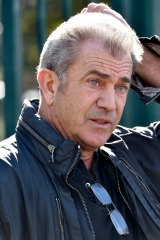 Mel Gibson is accused of pushing a photographer outside a Paddington cinema.
