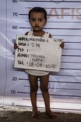 Norfouna, a Rohingya migrant child, poses for identification purposes at a temporary shelter in Indonesia.